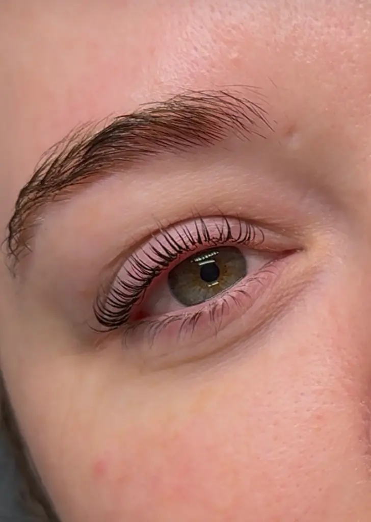 Woman getting natural lash enhancement with lift and black tint at Coastal Glo Med Spa